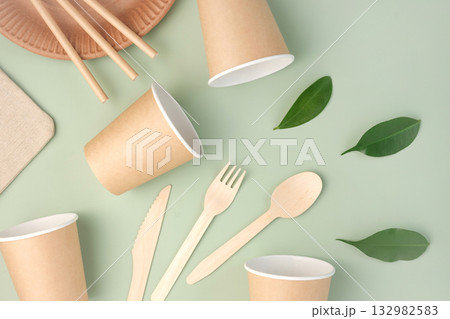 Eco Friendly Tableware on Green Background. Top View. Plastic free Set of Brown Paper Utensil. Street Food Recyclable Packaging. Zero waste Paperware. Mockup. Disposable Take out Cup, wooden cutlery Eco Friendly Tableware on Green Background. Top View. Plastic free Set of Brown Paper Utensil. Street Food Recyclable Packaging. Zero waste Paperware. Mockup. Disposable Take out Cup, wooden cutlery 132982583
