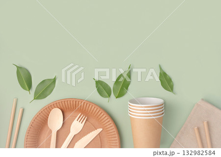 Eco - Friendly Tableware on Green Background. Top View. Plastic free Set of Brown Paper Utensil. Street Food Recyclable Packaging. Zero waste Paperware. Mockup. Disposable Take out Cup, wooden cutlery Eco - Friendly Tableware on Green Background. Top View. Plastic free Set of Brown Paper Utensil. Street Food Recyclable Packaging. Zero waste Paperware. Mockup. Disposable Take out Cup, wooden cutlery 132982584