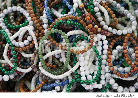 Pile of natural stone bead bracelets in various earthy colors 132983167