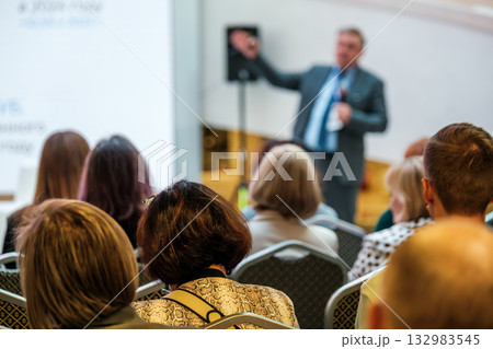 Business conference speaker presents to attentive audience during professional seminar Business conference speaker presents to attentive audience during professional seminar 132983545