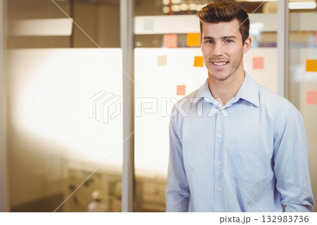 Man in business casual attire standing at office glass partition with sticky notes, copy space Man in business casual attire standing at office glass partition with sticky notes, copy space 132983736