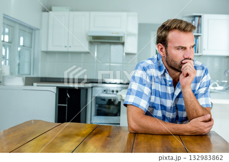 Middle-aged man leaning on wooden table in modern kitchen with stainless steel stove, copy space Middle-aged man leaning on wooden table in modern kitchen with stainless steel stove, copy space 132983862
