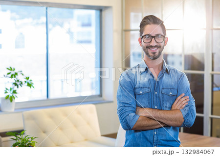 Man standing near light sofa and glass partition in office lounge with potted plants, copy space Man standing near light sofa and glass partition in office lounge with potted plants, copy space 132984067