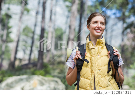 Female hiker exploring mountain forest trail wearing yellow vest and backpack with pad, copy space Female hiker exploring mountain forest trail wearing yellow vest and backpack with pad, copy space 132984315