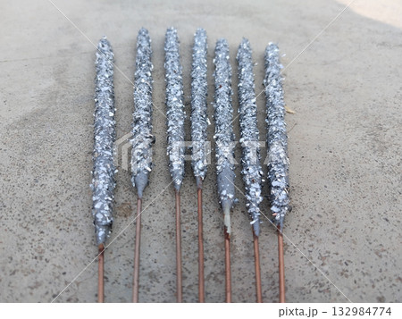 Close-up of multiple unused Diwali sparklers scattered on ground surface, unboxed fireworks with colorful sticks lying on floor before use during Indian festive preparation scene Close-up of multiple unused Diwali sparklers scattered on ground surface, unboxed fireworks with colorful sticks lying on floor before use during Indian festive preparation scene 132984774