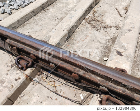 Close-up view of a railway track joint with concrete sleepers and stone ballast, showcasing Indian railway infrastructure, train track construction, and transportation engineering detail Close-up view of a railway track joint with concrete sleepers and stone ballast, showcasing Indian railway infrastructure, train track construction, and transportation engineering detail 132984806