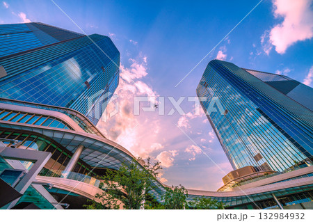 日本の東京都市景観　高輪ゲートウェイ駅前の高輪ゲートウェイシティなどを望む。上空に航空機（E2連続） 132984932