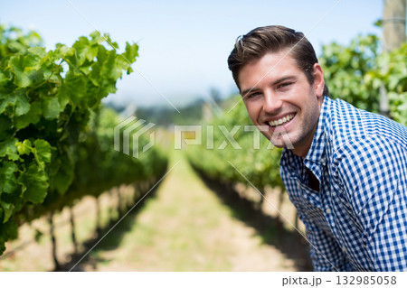 Man with fair skin leaning between grapevine rows smiling at vineyard under sunny sky, copy space Man with fair skin leaning between grapevine rows smiling at vineyard under sunny sky, copy space 132985058