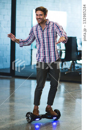 Man balancing on hoverboard inside modern office on polished concrete floor with glowing LED lights 132985284