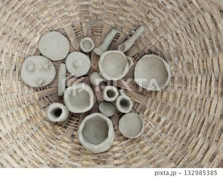 Handmade clay toy utensils created by children, placed in a woven bamboo basket, representing rural creativity, childhood imagination, and traditional Indian village play culture Handmade clay toy utensils created by children, placed in a woven bamboo basket, representing rural creativity, childhood imagination, and traditional Indian village play culture 132985385