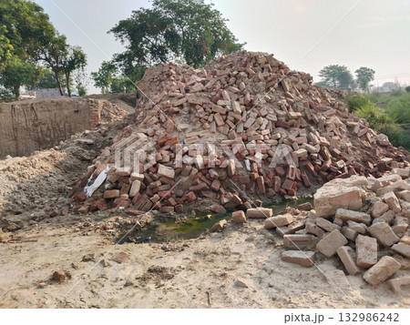 Completely demolished small brick and concrete bridge over dry stream, showing exposed debris and broken structure, prepared for reconstruction in rural area or semi-urban landscape 132986242