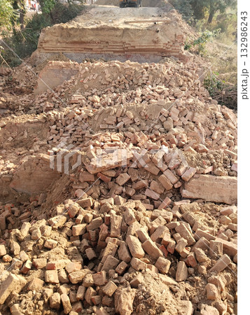 Demolished Old Bridge with Scattered Bricks and Earth Preparing for New Construction Reflecting Rural Development and Modern Engineering Under Open Sky with Vegetation and Future Infrastructure Plans 132986243