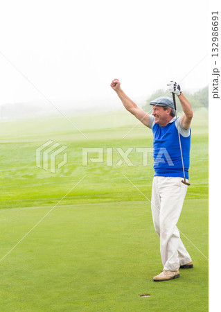 Senior African American man raising arms on putting green with golf putter and glove, copy space 132986691