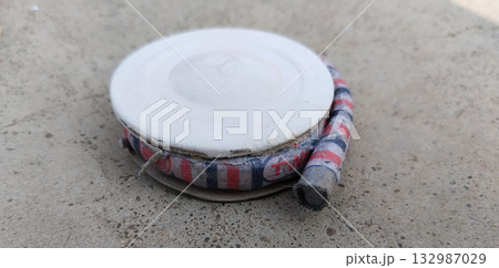 Unlit chakri firework spinners arranged on ground surface for celebration, traditional Indian fireworks display preparation with colorful circular crackers before ignition 132987029