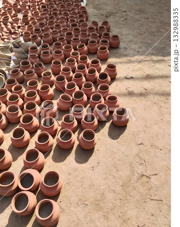 Multiple baked clay pots arranged on ground after firing process, showcasing traditional earthen cookware used in rural Indian kitchens for storage and cooking purposes Multiple baked clay pots arranged on ground after firing process, showcasing traditional earthen cookware used in rural Indian kitchens for storage and cooking purposes 132988335
