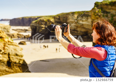 Woman with camera at Cathedral Beach in Spain. 132988759