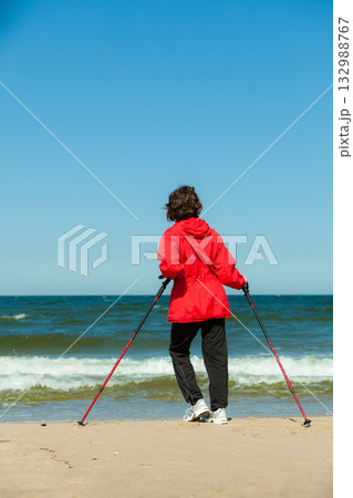 Nordic walking. Woman hiking on the beach. Nordic walking. Woman hiking on the beach. 132988767