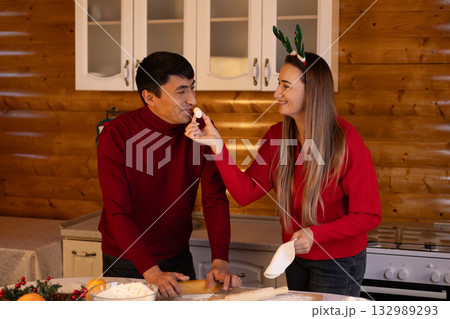 A couple is preparing Christmas treats in the kitchen A couple is preparing Christmas treats in the kitchen 132989293
