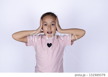 Little girl covering her eyes with hands, peeking through fingers, 132989379