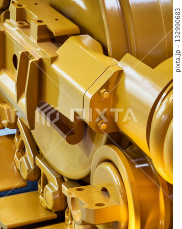Close-up view of heavy machinery components in vivid yellow color showcasing industrial design and engineering details 132990683