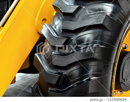 Heavy-duty tractor tire showcasing rugged tread design for enhanced traction and stability on uneven terrain 132990684