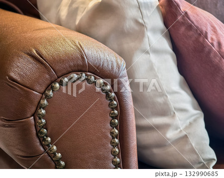 Elegant leather sofa corner with decorative pillows in a cozy living room setting 132990685