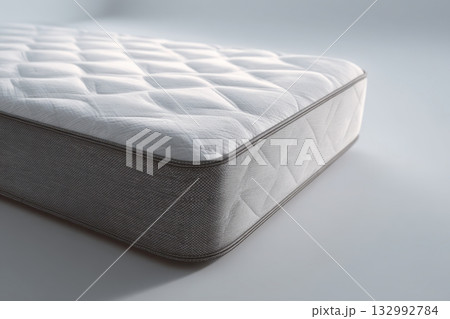 Mattress against white background. Memory foam mattress. Close up white orthopedic mattress corner, copy space for text. Hypoallergenic bed base for proper spinal alignment and pressure point relief. Mattress against white background. Memory foam mattress. Close up white orthopedic mattress corner, copy space for text. Hypoallergenic bed base for proper spinal alignment and pressure point relief. 132992784