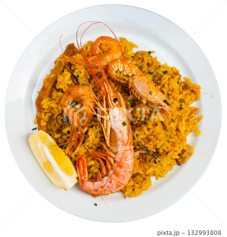 Paella made of rice and different seafood served in plate with table appointments 132993808