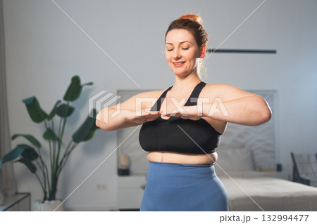Fitness workout training. Woman practicing fitness at home. Plus size female doing sports exercise at home indoor. Girl in sportswear have workout weight training for weight loss. Sport and fitness Fitness workout training. Woman practicing fitness at home. Plus size female doing sports exercise at home indoor. Girl in sportswear have workout weight training for weight loss. Sport and fitness 132994477