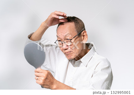 鏡を見て髪を気にするシニア男性 ヘアケア 鏡を見て髪を気にするシニア男性 ヘアケア 132995001