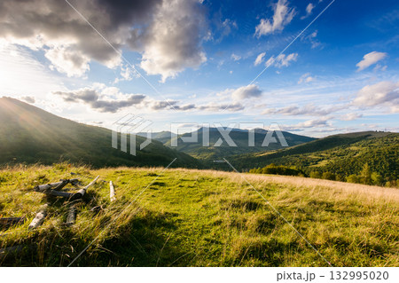 beautiful countryside of ukraine. sunny afternoon. wonderful summertime landscape in mountains. scenic view of green grassy field and rolling hills for great background. rural scenery under blue sky. 132995020