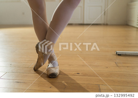 Worn ballet pointe shoes on feet in dance class. Well worn pointe shoes of ballet dancer. Classical ballerina woman in dance studio. Classical pointe shoes for dance training. Ballet school concept 132995492