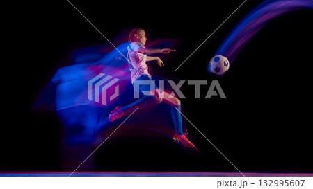 Soccer player kicking ball in air with glowing light motion 132995607