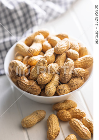 Peanuts in shell. Groundnuts in bowl on white table. Peanuts in shell. Groundnuts in bowl on white table. 132995900