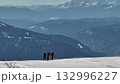 Mountaineers standing on snowy mountain ridge enjoying scenic view 132996227
