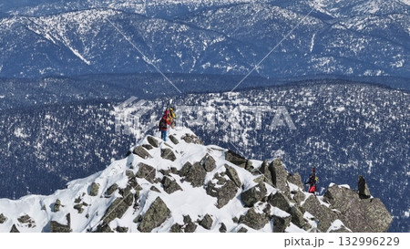 Mountaineers reaching snowy mountain peak Mountaineers reaching snowy mountain peak 132996229