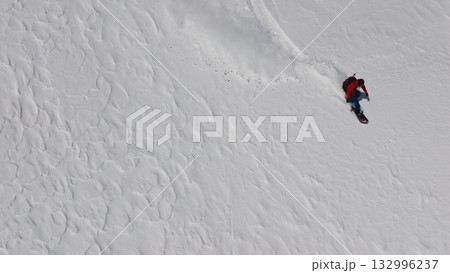 Snowboarder riding fresh powder snow on mountainside Snowboarder riding fresh powder snow on mountainside 132996237