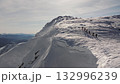Climbers traversing snowy mountain ridge in stunning winter scenery 132996239