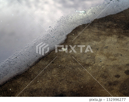 The reflection of the clouds and sky on the flood puddle on the road 132996277