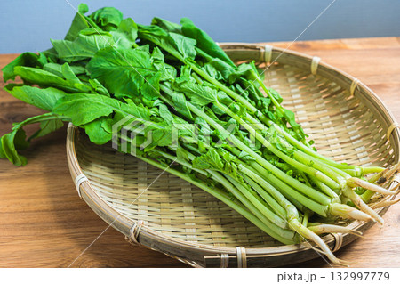 葉大根　木目テーブルの竹ざるに乗せた新鮮な大根菜 132997779