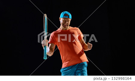 Male tennis player celebrating match win with powerful emotion and raised hands 132998164