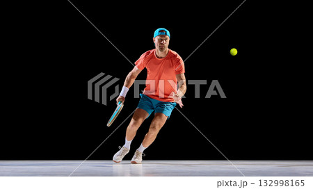 Focused tennis player tracking ball with strong eye contact and balance 132998165