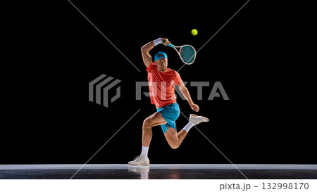 Tennis player jumping in action to hit high ball with intensity and control 132998170