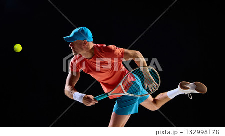 Concentrated tennis player preparing for return with intensity and power Concentrated tennis player preparing for return with intensity and power 132998178