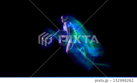 Basketball player performing aerial trick in neon motion trail. Basketball player performing aerial trick in neon motion trail. 132998262