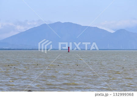 The view of the seascape and a red lighthouse in the center of the sea. Calm seascape with the blue sky in the sunny day, Nature concept. 132999368