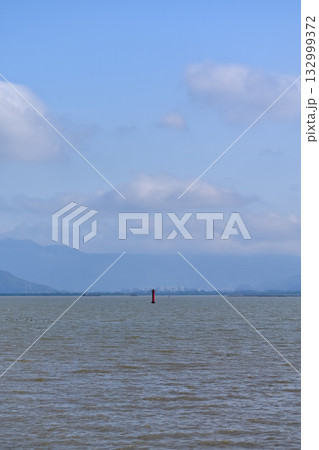The view of the seascape and a red lighthouse in the center of the sea. Calm seascape with the blue sky in the sunny day, Nature concept. The view of the seascape and a red lighthouse in the center of the sea. Calm seascape with the blue sky in the sunny day, Nature concept. 132999372