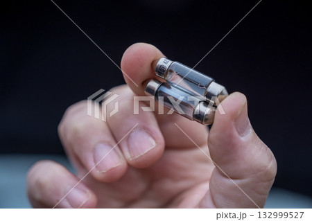Halogen car new and old lamp bulb. Male hand holding car parts Halogen car new and old lamp bulb. Male hand holding car parts 132999527