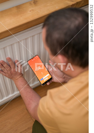 Smartphone connecting to heating radiator. Remote home control system on a smartphone. 132999532