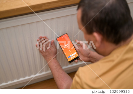 Smartphone connecting to heating radiator. Remote home control system on a smartphone. Smartphone connecting to heating radiator. Remote home control system on a smartphone. 132999536